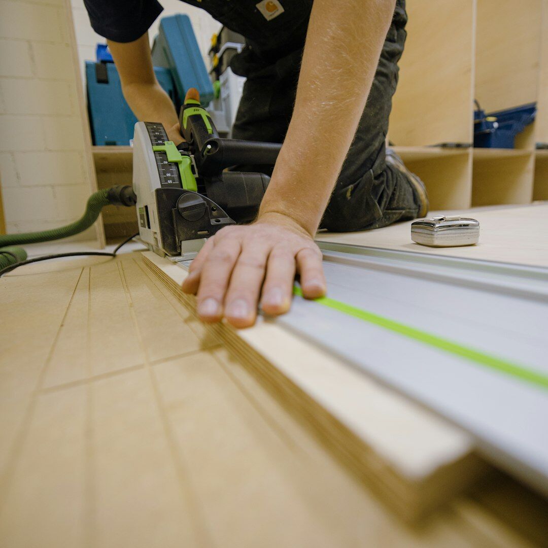 Swiss graphic designer working at a drafting table with layout sheets and typographic rulers